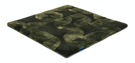 Handmade velvet rug in shades of dark green with patch finishes of the same light color