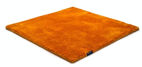 braided and hand-woven rug in wool and velvet in a orange color tone