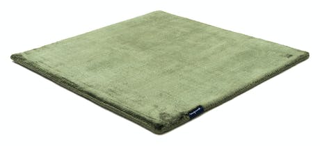 rug made of shiny velvet fabric in a green color tone