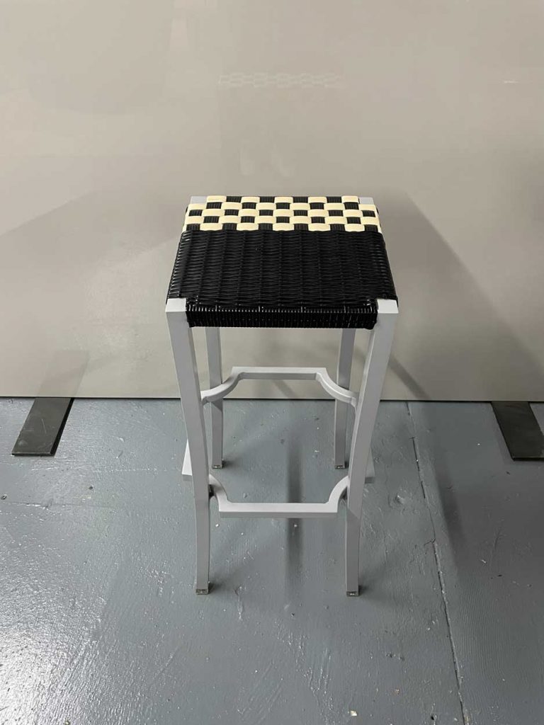 stool made of aluminum base and hand-woven seat in an ivory and black tone