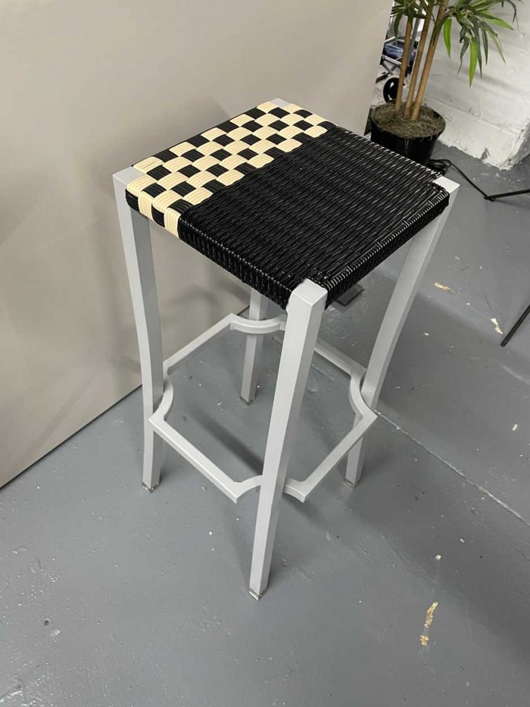 stool made of aluminum base and hand-woven seat in an ivory and black tone