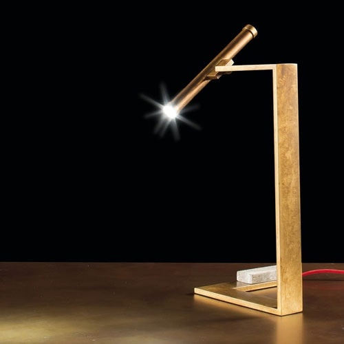 Let Flat Lamps with brass pipe structure, multi directional light, power lead with red silk cover, counterweight in stone on a black background.