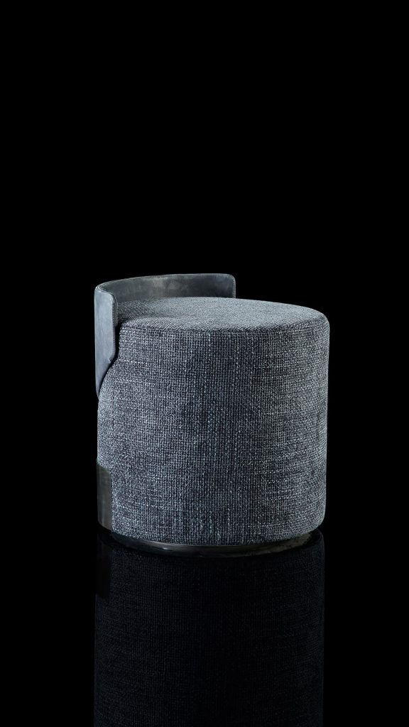 Gelly Pouf upholstered in blue leather and a base in black steel on a black background.