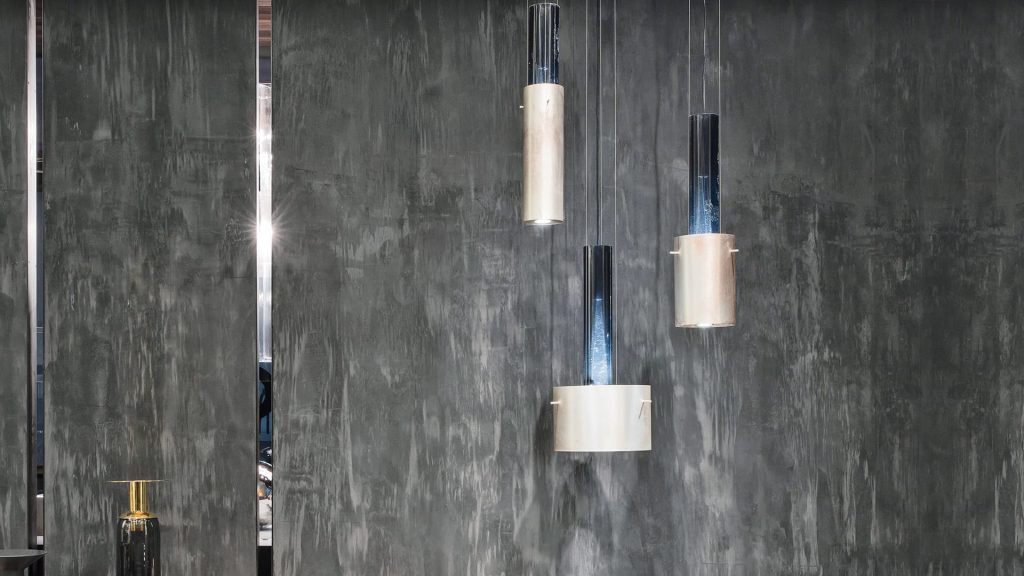 Three pendant Ghost Lights. Central element in resin and brass light diffuser on a gray blackground.