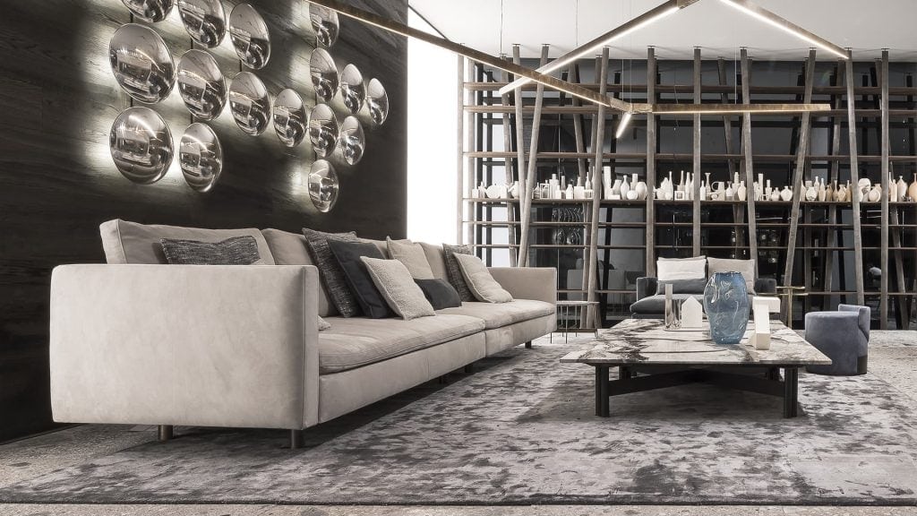 Two Human Sofas with armrest and backrest upholstered in gray fabric with black brass legs in a living room.
