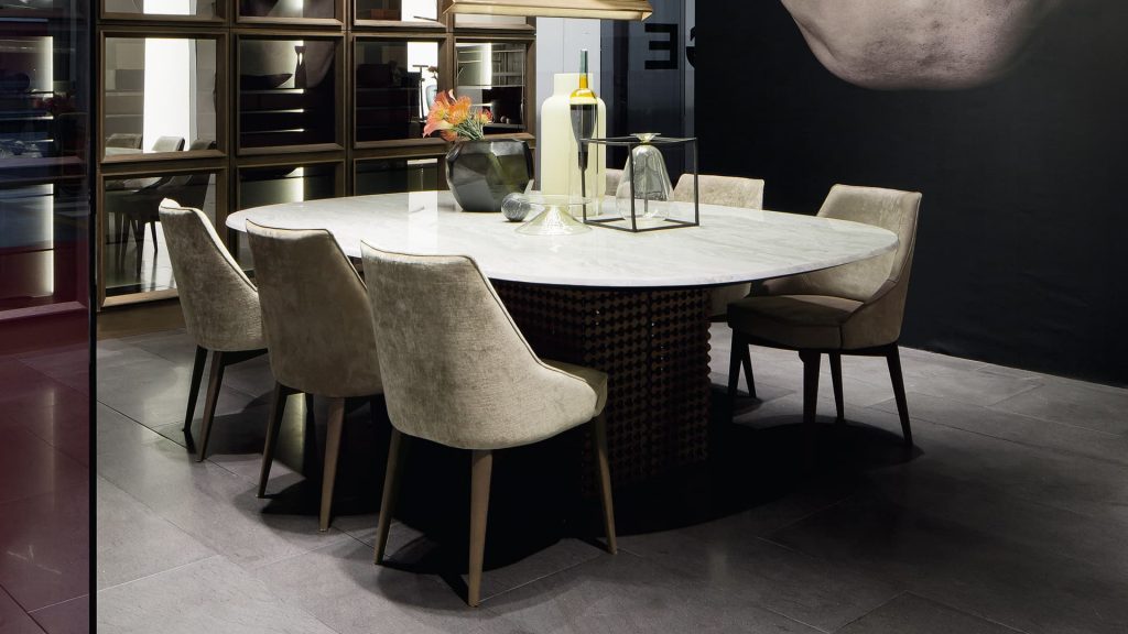 Six Is A Chair in gray fabric with for legs in black eucalyptus wood in a living room.
