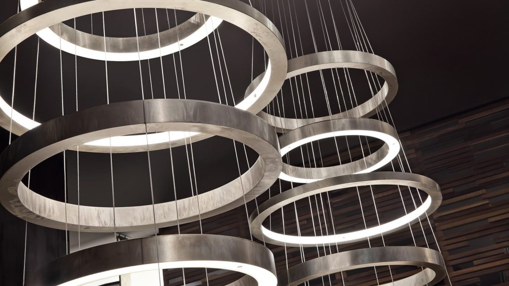 Two LED Pendant Lights Ring made up of four silver rings using suspension wires on a black background.