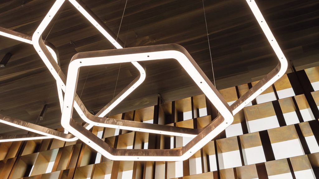 polygon-shaped lamps in a brass color tone with LED lighting in a living room