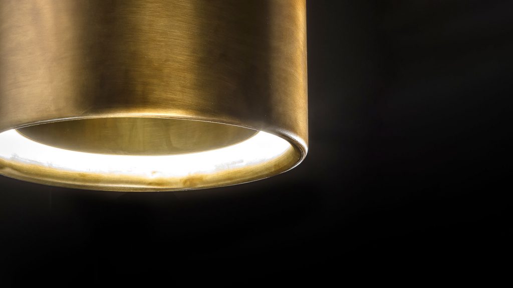 lamp in the shape of long rings on a burnished brass base in a gold tone