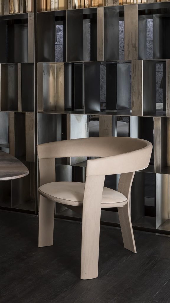 Beige Noce Chair, structure and three legs in wood. Padded seat and backrest with leather on a gray background.