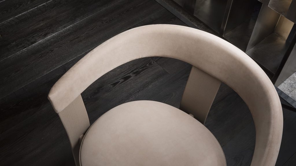 Beige Noce Chair, structure and three legs in wood. Padded seat and backrest with leather on a brown floor.