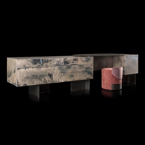 Noctis Vanity cabinet with three doors. Outside covered with burnished steel, three legs in black steel and a stool on a black background.