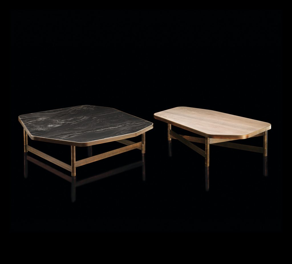 Two OR Tables, structure with an irregular polygon shape and four legs in brass tube, top in wood, left in black and right in white on a black background.