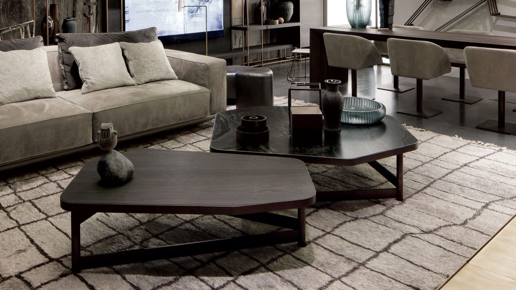 Two OR Tables, structure with an irregular polygon shape and four legs in brass tube, top in black wood in a living room.