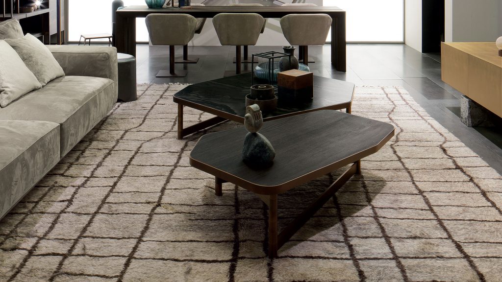 Two OR Tables, structure with an irregular polygon shape and four legs in brass tube, top in black wood in a living room.