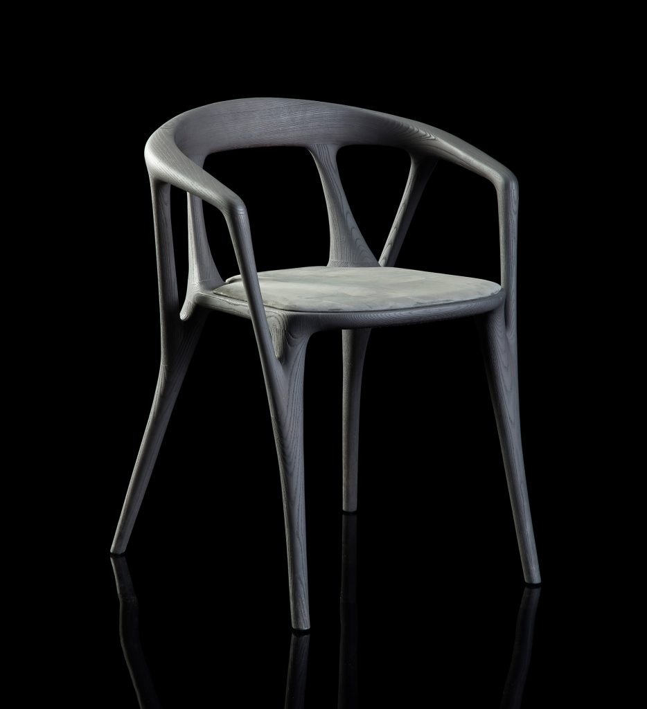 Savanna dining chair in black wood with four legs. Seat covered with black leather on a black background.