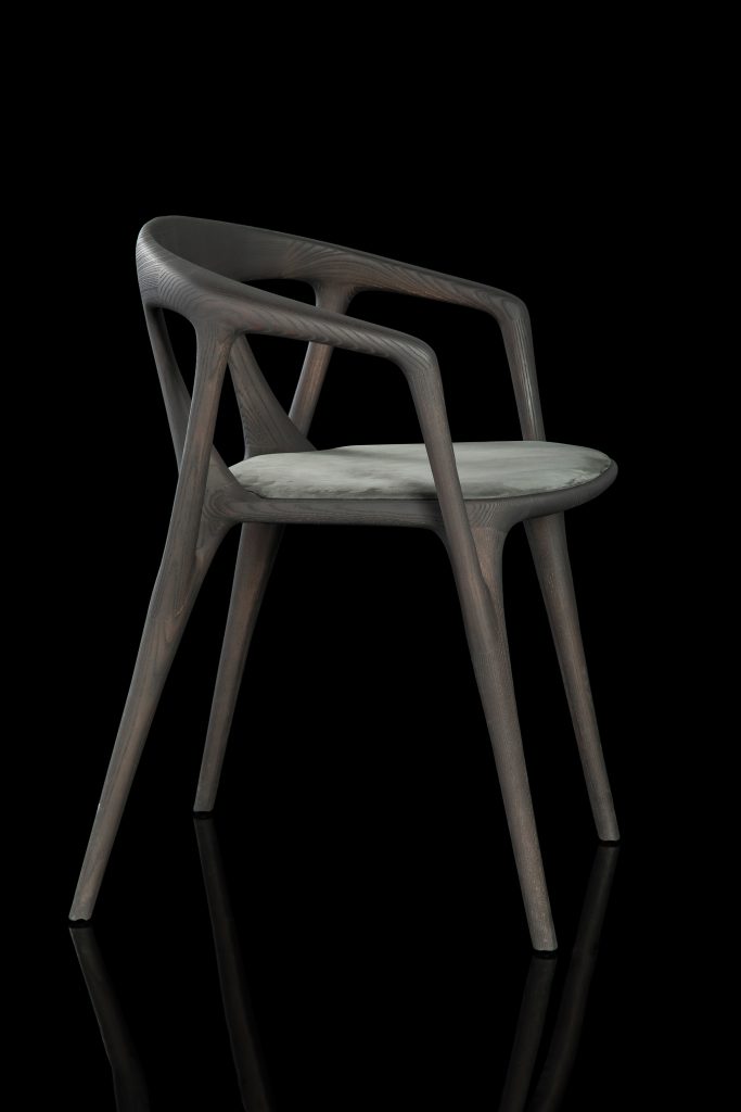 Savanna dining chair in black wood with four legs. Seat covered with black leather on a black background.