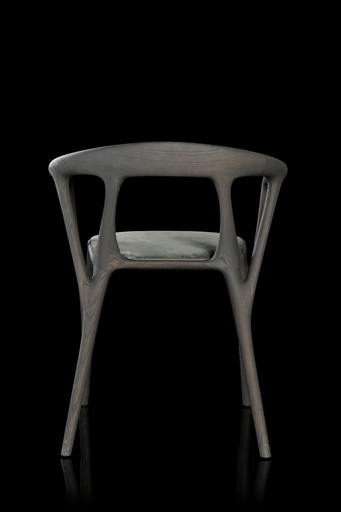 Savanna dining chair in black wood with four legs. Seat covered with black leather on a black background.