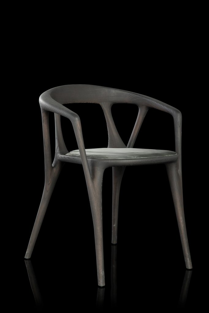 Savanna dining chair in black wood with four legs. Seat covered with black leather on a black background.