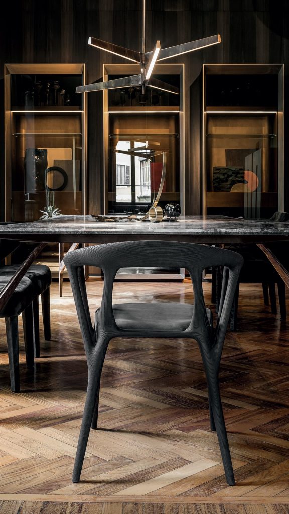 Three Savanna dining chairs in black wood with four legs. Seat covered with black leather in a dining room.