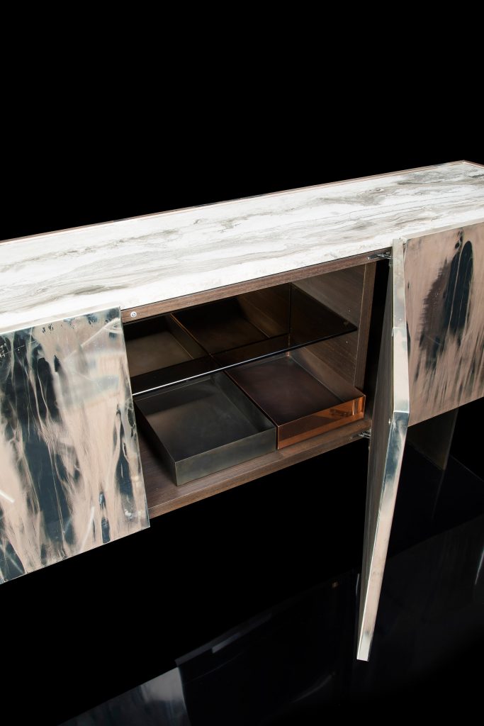 Side X Evo table, structure in natural wood covered with silver metal and top in brown and white marble pattern stone in a living room.