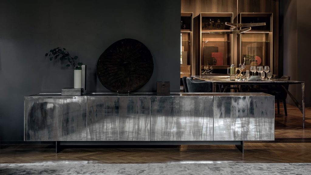 Side X Evo table, structure in natural wood covered with silver metal and top in brown and white marble pattern stone in a living room.