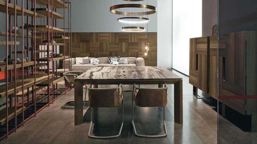 Soprano dining table, structure and four legs in brown wood, top in white, grey, brown and black stone in a dining room.