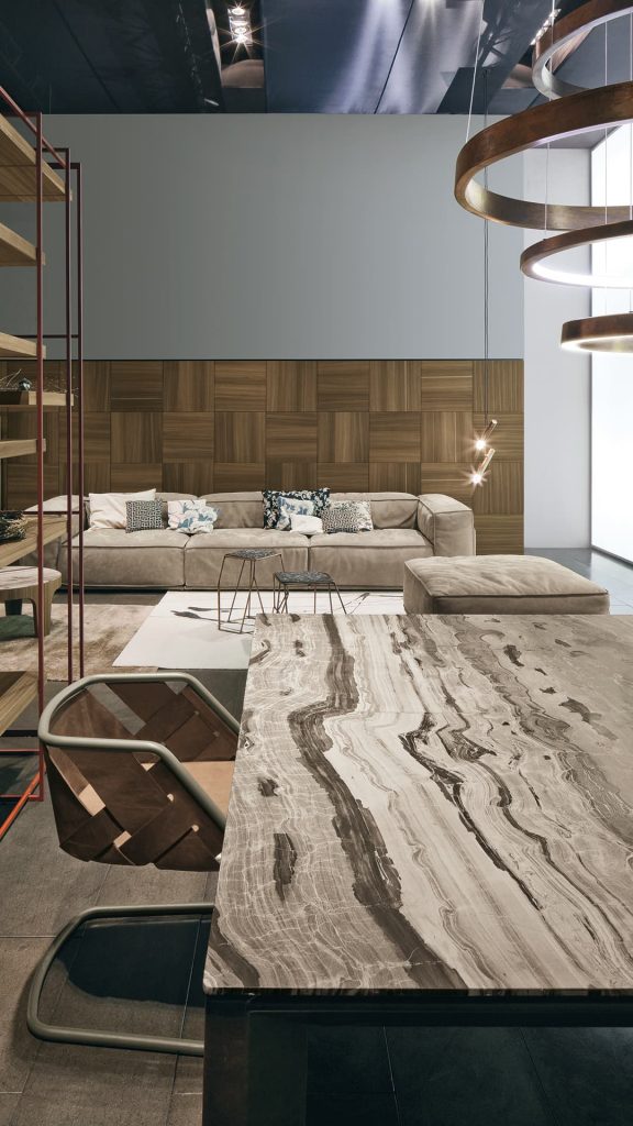 Soprano dining table, structure and four legs in brown wood, top in white, grey, brown and black stone in a dining room.