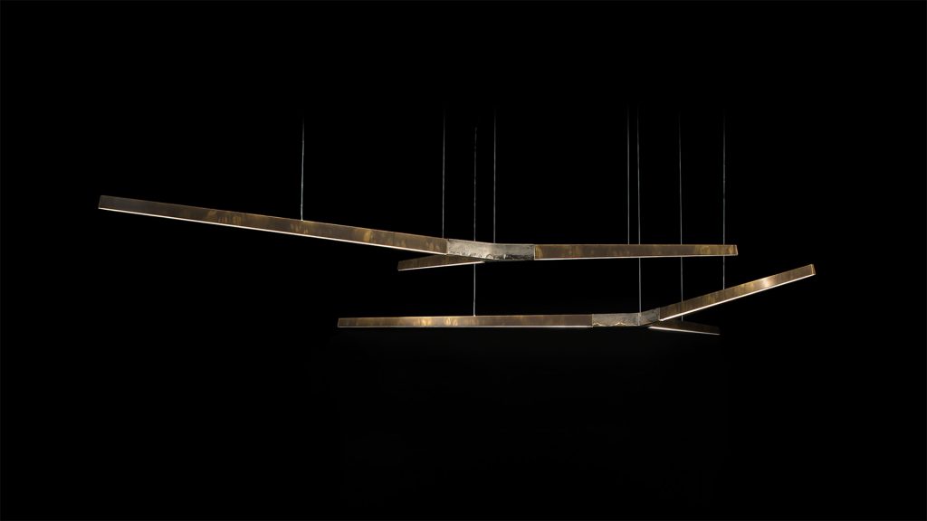 Two Starlight Horizontal led lamps with with Y shaped central body in sandcasting brass using suspension cables on a black background.
