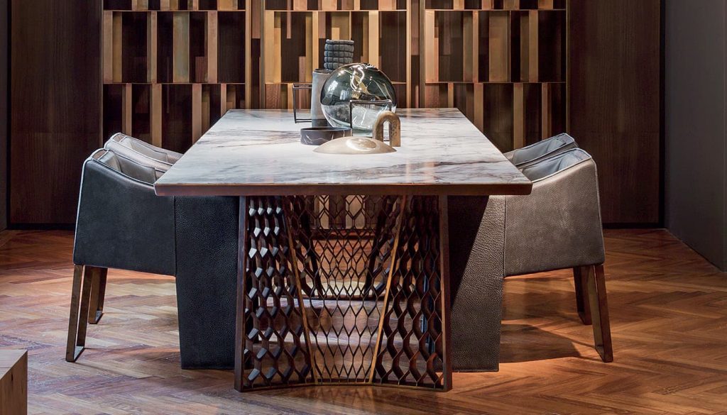 Stealth Table, legs in brass finish with rhombus pattern, top in white and gray marble stone in a dining room.