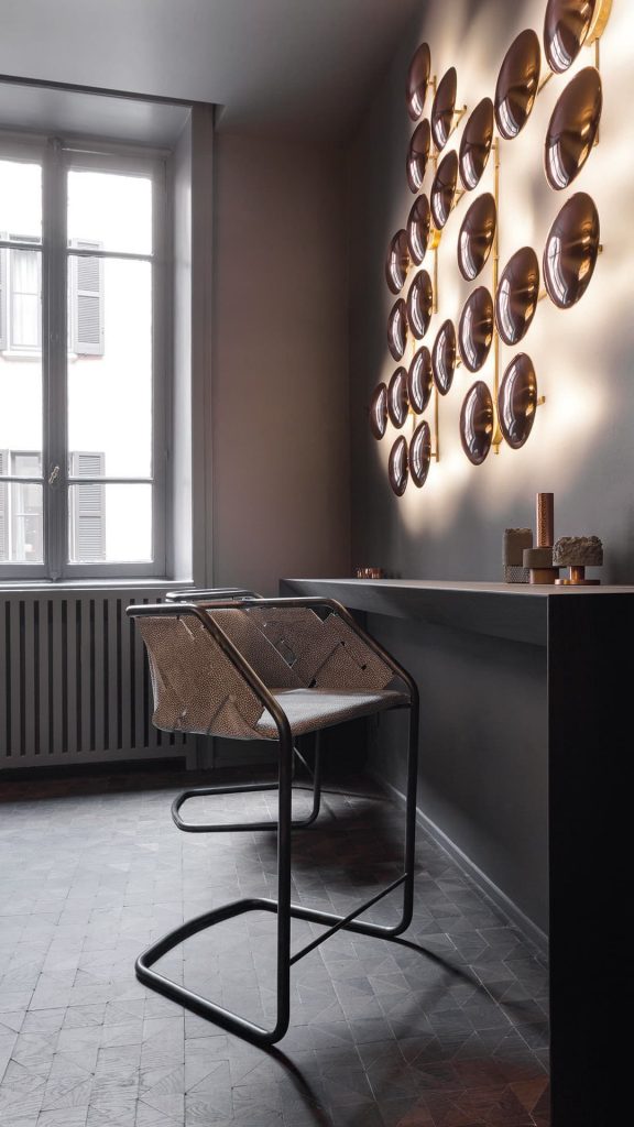Two Strip Stools. Structure in curved black metal frame, seat covered with brown leather on a study room.