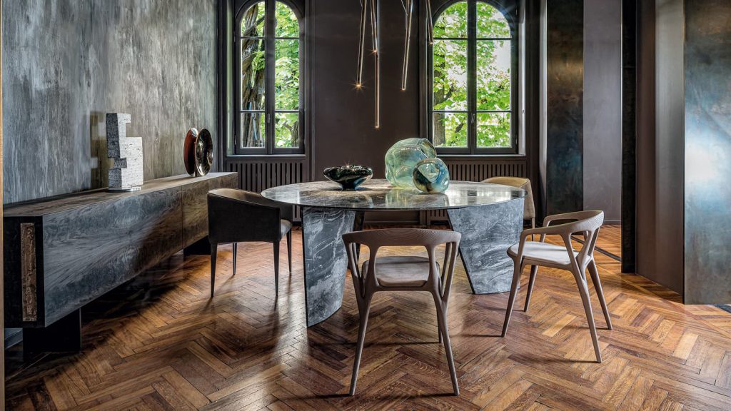 Round Synapses Table with three legs, white and black marble lines in a dining room.