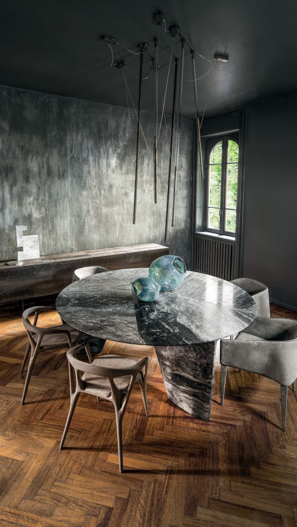 Round Synapses Table with three legs, white and black marble lines in a dining room.