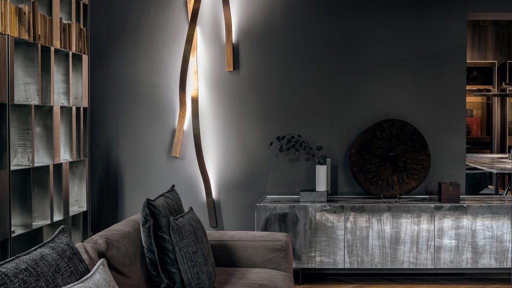 wall lamp made in the shape of a curved flame in burnished brass in a bronze tone