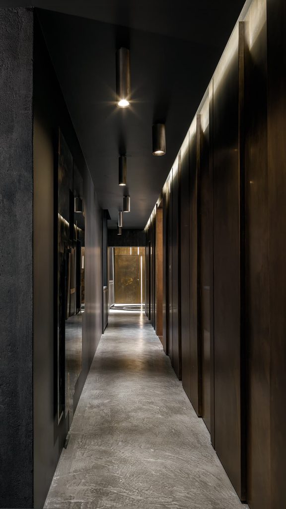 Five cylindrical ceiling Tele Lights made of burnished brass and silver in a hallway.