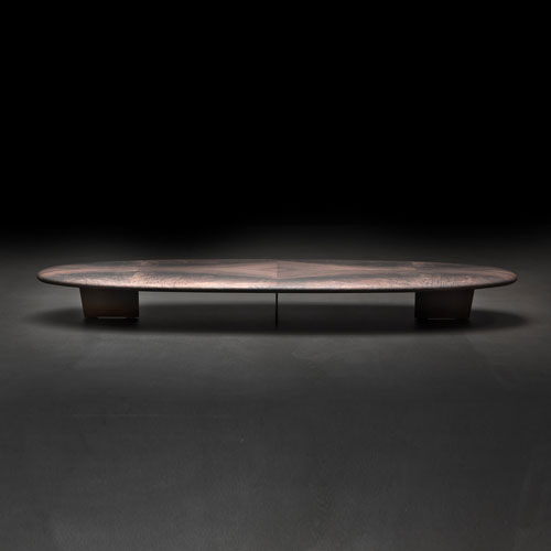 table made of black burnt steel top in h-piuma wood in a bronze burnished color tone on a black background