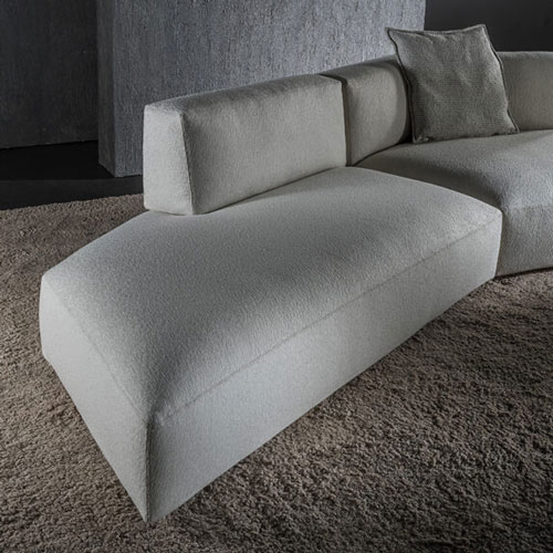 sofa made of burnished brass and foam cushions upholstered in white fabric in a living room
