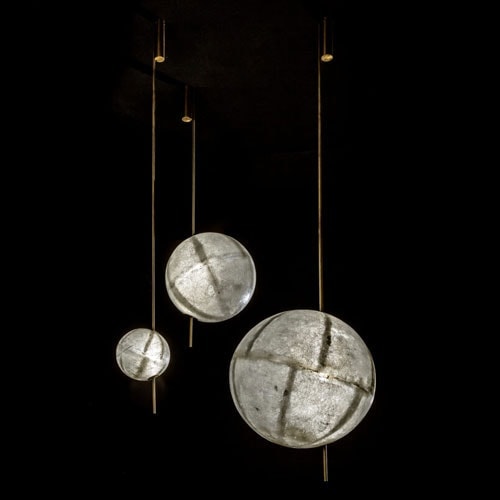 three LED lamps made of fiberglass in a tone of gray with gold on a black background