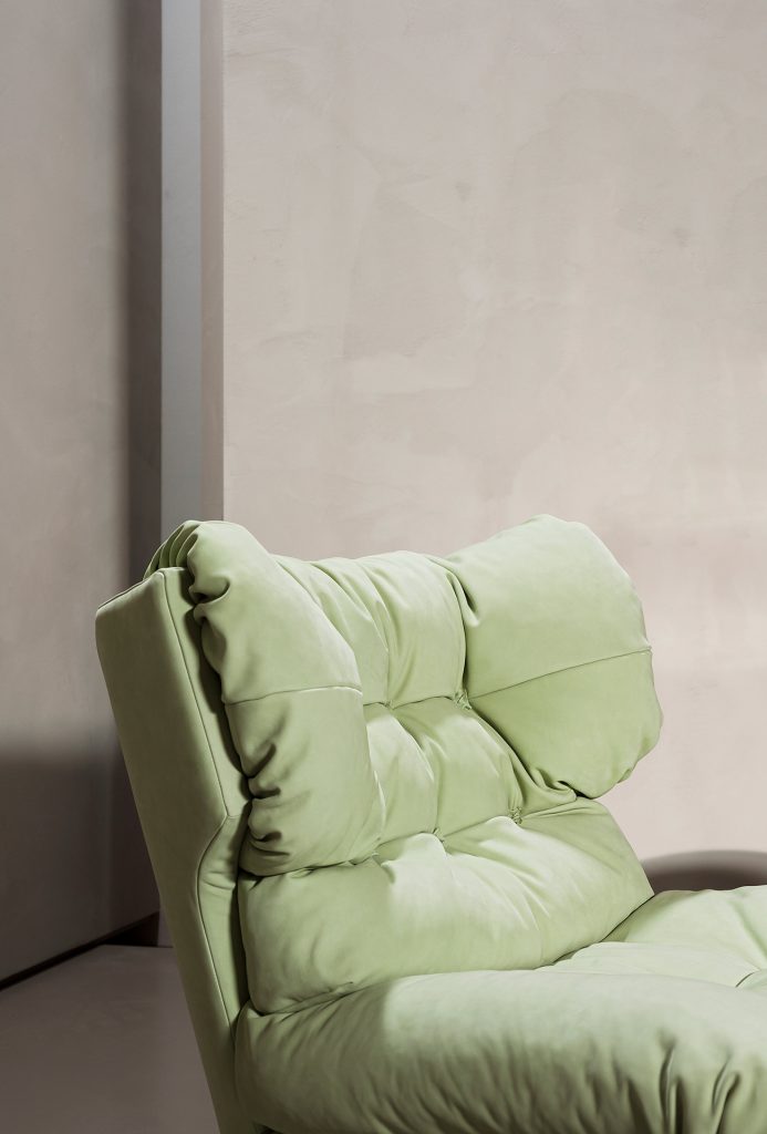 armchair made of leather in a light green tone with button design in a living room