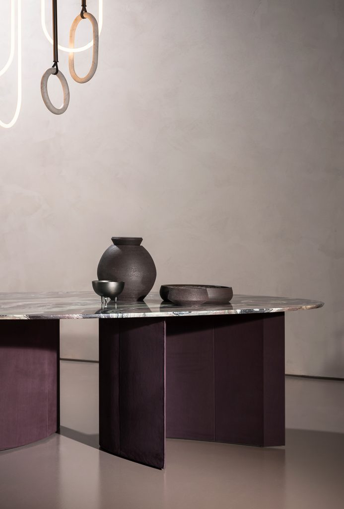 Drop-shaped table made of marble in a varied color tone in an office with a stone base in a brown tone