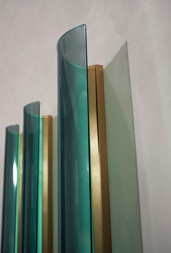 three-panel wall light made of glass and aluminum and glass in a green and gold tone