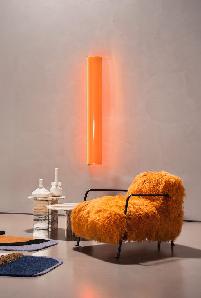 wall light made of glass and aluminum in an orange tone in a living room