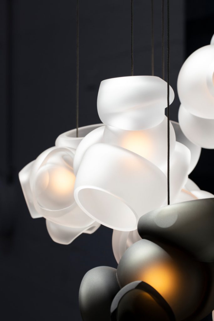 Close up of One Hundred Clear with Gray light in front of a black background