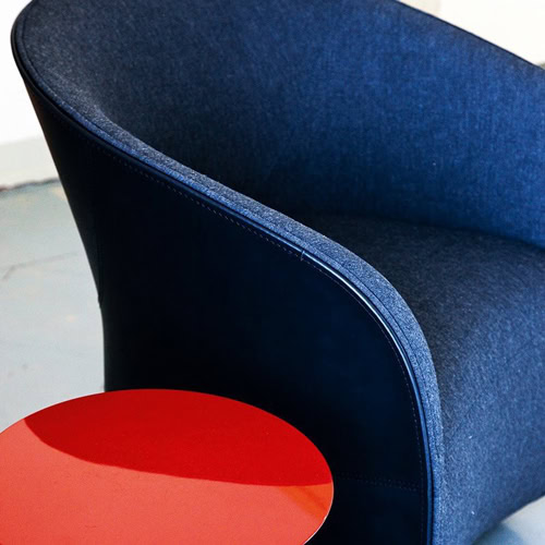 Calla armchair upholstered in blue fabric on a gray background.