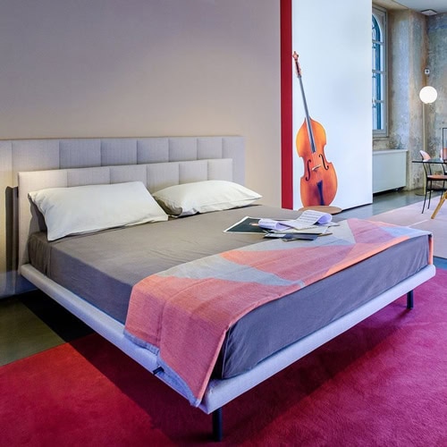 Grangala bed, Base and doble headboard in white with square pattern and four black legs in a bedroom.