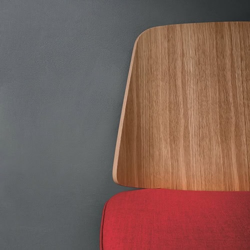 June chair with a red cushioned seat and natural wood backrest on a gray background.