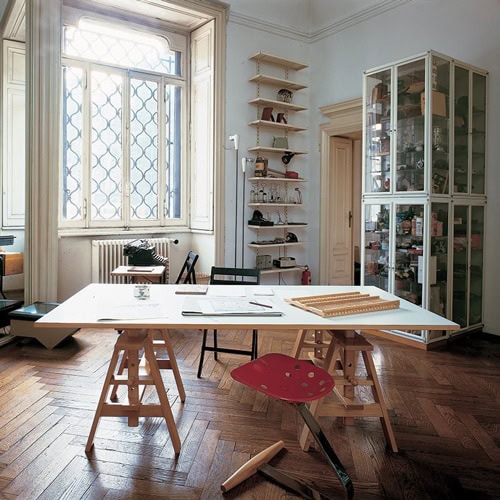 Square Leonardo table featuring a white wooden top and four wooden sturdy legs in a office.
