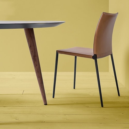 Lia chair featuring a black metal frame and four legs. Brown cushioned seat and backrest in a dining room.