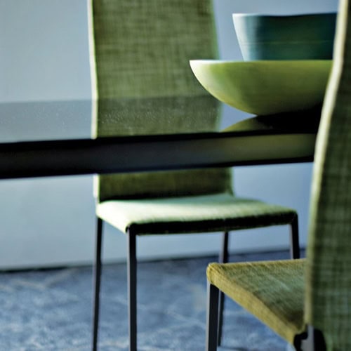 Two Lialta chairs featuring a metal frame and four legs and a green cushioned seat and backrest in a dining room.