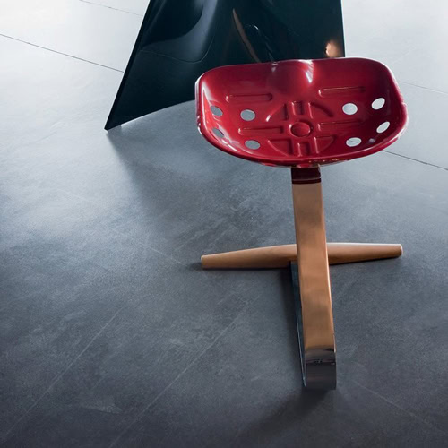 Mezzadro red stool with a unique design, featuring a red seat on a chrome base on a gray background.
